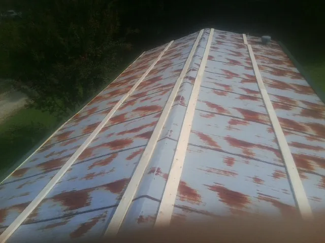 Rusted metal roof panels with new wood purlins before replacement — Storm Damage Roof Repair in Malcom by Roofing Brothers